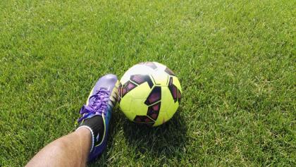 foot kicking a football ball